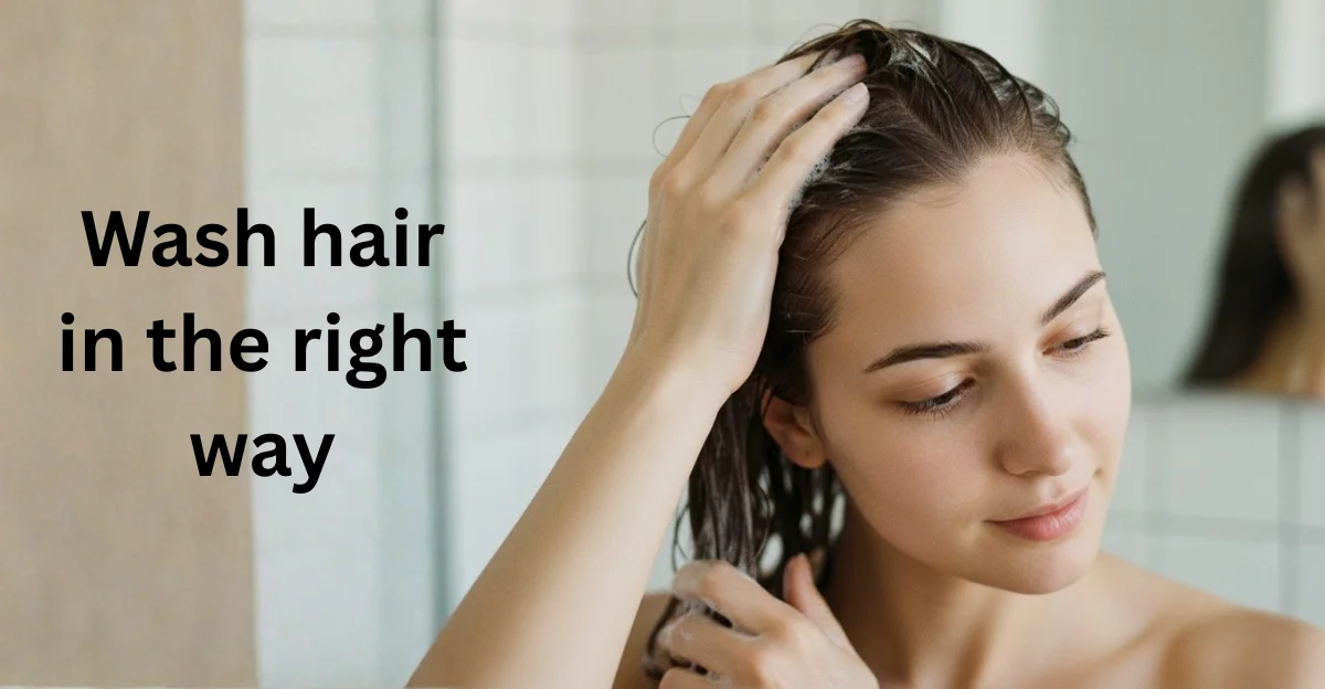 A woman in a shower applying shampoo to her roots, illustrating the correct way to wash hair for maximum volume and scalp health.