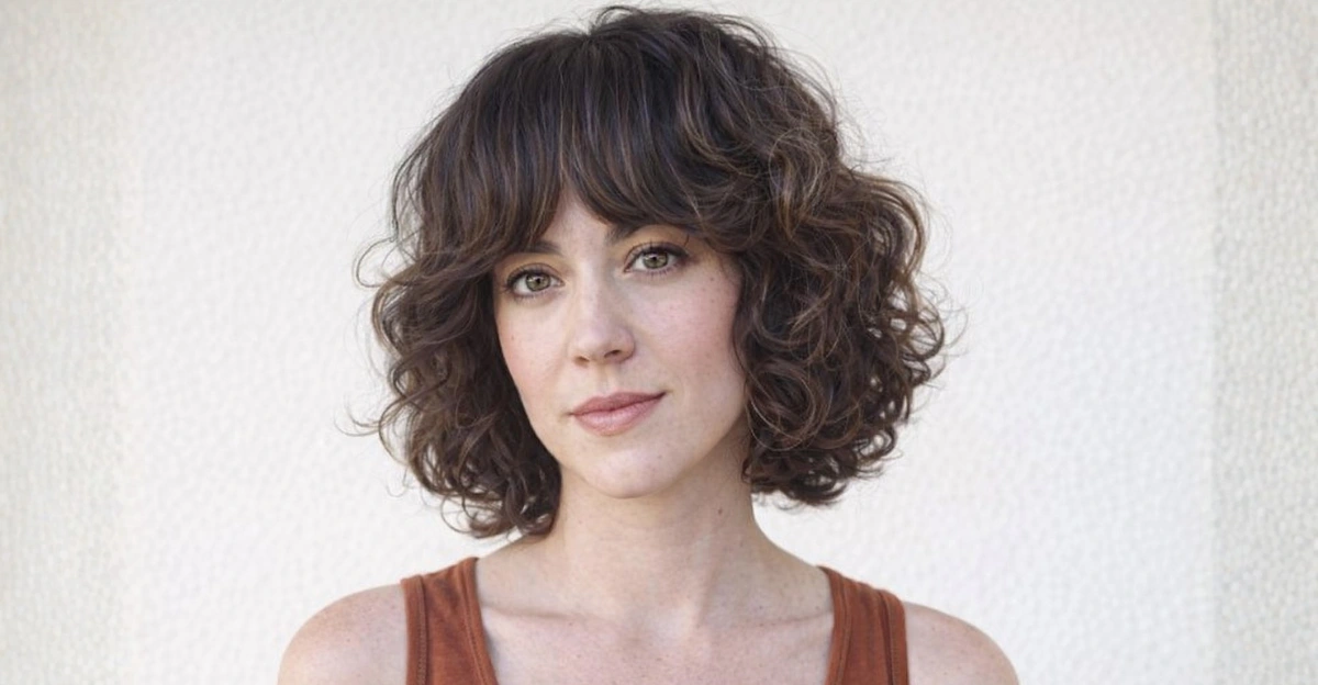 Wavy layered short bob haircut with chunky bangs and defined, bouncy texture.
