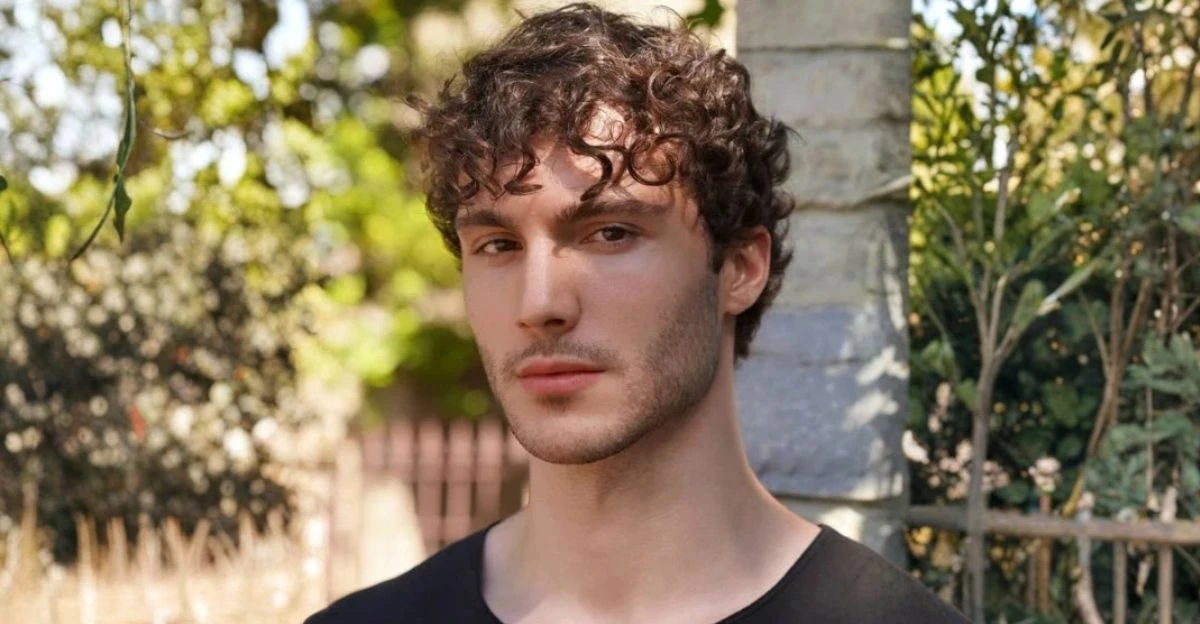 Curly fringe haircut with forward curls that naturally cover and soften a big forehead.